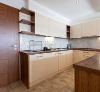 Kuchyně v 2-pokojovém bytě se světlými skříňkami a podlahou s dřevěným dekorem.