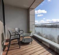 Balkon v 2-pokojovém bytě s výhledem na řeku, podlaha s dřevěným dekorem.