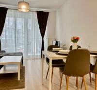 2-pokojový byt s podlahou s dřevěným dekorem, jídelním stolem a pohovkou.