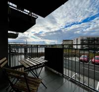 Balkon 2-pokojového bytu v Bielom Kostole s výhledem na parkoviště a oblohu.