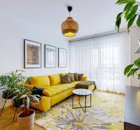 Barevný obývací prostor s rostlinami, žlutou pohovkou a dekorativními obrazy, 3pokojový byt.