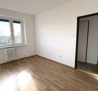 Světlý pokoj s podlahou s dřevěným dekorem v 3-pokojovém bytě.