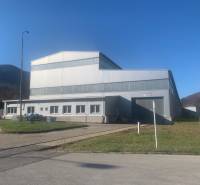 Výrobní prostory v Dobšiné s ocelovou konstrukcí obklopené přírodní scenérií a travnatými plochami.