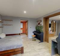 Pokoj v rodinném domě s pianem, postelí a podlahou s dřevěným dekorem.