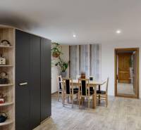 Jídelna v rodinném domě s dřevěným dekorem podlahy a prostornými skříňkami.