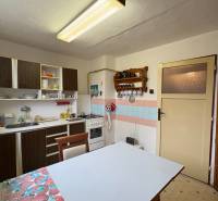 Kuchyně v rodinném domě s jídelním stolem a kuchyňským koutem.