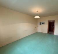 Pokoj v 3-pokojovém bytě s neutrálními stěnami a světlou podlahovou dekorací.