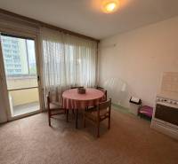 Kuchyně v 3-pokojovém bytě s jídelním stolem, elektrickým sporákem a přístupem na balkon.