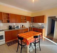 Kuchyně v rodinném domě s dřevěným dekorem a jídelním stolem.