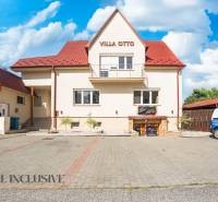 Budova s červenou střechou a vyhrazeným parkováním v Dunajské Stredě.