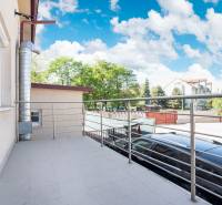 Balkon v Dunajské Stredě s výhledem na okolí budov a parku.