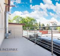 Balkon budovy v Dunajské Stredě s kovovým zábradlím a výhledem na okolí.