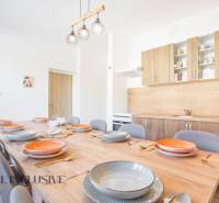 Kuchyně v budově, dřevěné skříňky, velký stůl s podlahou s dřevěným dekorem.