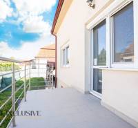 Budova v Dunajské Stredě s terasou a zábradlím, obloha s oblaky.