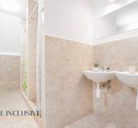 Koupelna se dvěma umyvadly a sprchou, dekorativní kachličky a zrcadlo v budově.