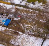 Zahrady v Nálepkově s ledovým sněhem, staršími přístřešky a oploceními v zimě.