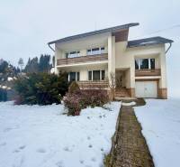 Rodinný dům na Čadečce v Čadci obklopuje zasněžená zahrada a bezúdržbové keře.