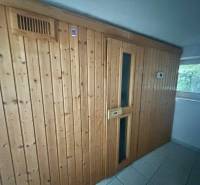 Dřevěná stěna se saunou a dlažbou v rodinném domě.