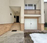 Rodinný dům na Čadečce v Čadci se schody a garáží, zbytky sněhu na příjezdové cestě.