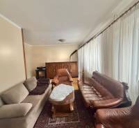 Obývací pokoj s pohovkami a konferenčním stolkem v rodinném domě.