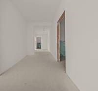 Chodba ve výstavbě ve 4-pokojovém bytě s neomítnutými průchody a neutrálními stěnami.