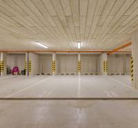 Podzemní parkovací místa s označenými sloupy ve barevném označení.