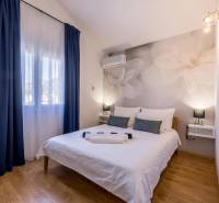 Ložnice ve vile s velkými květinami na stěně a podlahou s dřevěným dekorem.