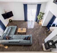 Vila s výhledem na obývací pokoj s modrou sedačkou a mramorovou podlahou.