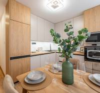 Kuchyně v 2pokojovém bytě s jídelním stolem a podlahou s dřevěným dekorem.