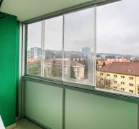 Zasklený balkon s výhledem na budovy na Třída SNP v Banské Bystrici.