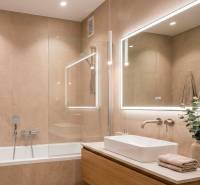 Koupelna v 2-pokojovém bytě s vanou, zrcadlem a světlými obklady.