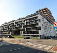 Budova na ulici Zuzany Chalupové v Bratislavě - Petržalce s parkovacími místy.