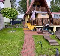 Chata v obci Nové Zámky s červenou střechou, terasou a zahradou na odpočinek.