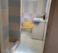 Koupelna v chatě s barevnými obklady a sprchovým koutem se zástěnou.