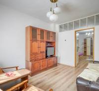 Obývací pokoj v rodinném domě s dřevěným nábytkem a pohodlným sezením.