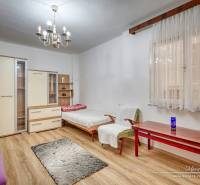 Rodinný dům s dřevěnou podlahou, lustry a nábytkem, pokoj s denním světlem.