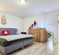 Ložnice v rodinném domě s podlahou s dřevěným dekorem a vánočními dekoracemi.