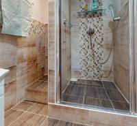 Koupelna v 3-pokojovém bytě s dlažbou a sprchovým koutem s moderními obklady.