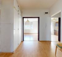 Chodba v 3-pokojovém bytě s podlahou s dřevěným dekorem a jednoduchým nábytkem.