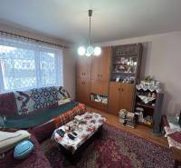 Obývací pokoj v rodinném domě s dekorativním kobercem a pohovkou.