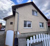 Rodinný dům v Zbehoch se šikmou střechou, plotem a příjezdovou cestou.