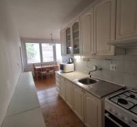 Kuchyně ve 3-pokojovém bytě s plynovým sporákem a jídelním stolem.