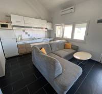 Kuchyně s rohovou pohovkou a jídelním stolem, rodinný dům, podlaha s tmavou dlažbou.