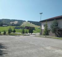 Lyžařský svah v Makově s přilehlou budovou a zelení v okolí.