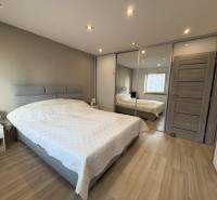 Ložnice v 2-pokojovém bytě s podlahou s dřevěným dekorem.