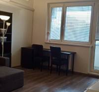 Obývací pokoj v 2-pokojovém bytě s rohovou sedačkou a podlahou s dřevěným dekorem.