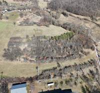 Letecký pohled na rozlehlé pozemky k bydlení v Krupině, s lesy a poli.