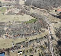 Letecký pohled na pozemky pro bydlení v Krupině, obklopené přírodou a stromy.