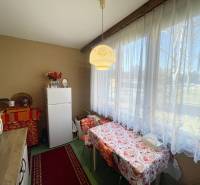 Kuchyně ve 3-pokojovém bytě s jídelním stolem a velkým oknem.