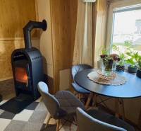 Krb v obývacím pokoji rodinného domu s kulatým stolem a dvěma židlemi.